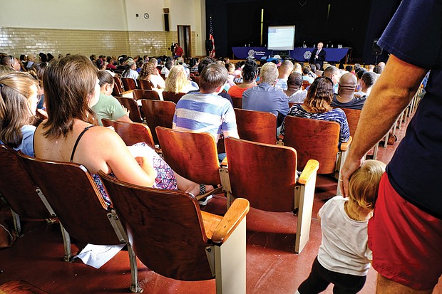 Richmond Public Schools Interim Superintendent Tommy Kranz addresses a packed auditorium during Monday’s public hearing on conditions at George Mason Elementary School in the East End. Below, Hope Talley, a fourth-grade teacher at George Mason Elementary, wears a mask to prevent her allergies from flaring up. She said they are aggravated by mold in the building.