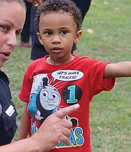 In the right direction //
Three-year-old Tristian Levere of Henrico County directs the attention of Richmond Police Office Monica Fecht on Tuesday to a spot at Pollard Park during National Night Out festivities. The youngster built his own connection with the officer at the event to strengthen neighborhoods, reduce crime and build connections. Please see more photos, A2.
