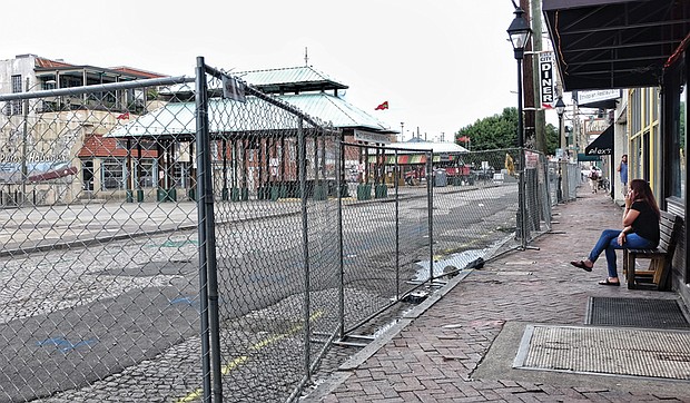 
Fencing blocks off 17th Street and the Farmers’ Market — the first step in a $4.3 million facelift that will transform the street and the marketplace between Main and Franklin streets into a European-style plaza. Despite the work, restaurants and shops that face the market remain open for business, with owners and operators hoping customers will continue to stop by. The transformation is expected to be finished by March. When done, the revamped market is to be the outdoor extension of nearby Main Street Station, whose interior has been redone and includes a huge, glass-faced event space, a soon-to-open tourist welcome center and room for retail shops. The project is part of the city’s spending to rejuvenate the Shockoe Bottom area. Nearby to the west, the city plans to invest more than $19 million to develop a museum-style space to recall Richmond’s role in the slave trade more than 150 years ago. 