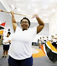 Satin Diva flaggers, from left, Tiara Coleman, a freshman from Chesapeake, Aiyhana Murdock, a senior from Richmond, and Brianna Trice a sophomore from Chesapeake, make the moves that are coordinated with the band and its music.
