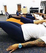 Taylor McClenny, a senior from Chesterfield County, and her five fellow tuba players undergo breathing exercises during a sectional practice. Rigorous calisthenics are part of the training to prepare band members for the season.