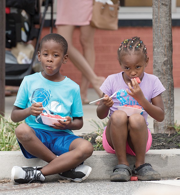 Fun, sun and watermelon //
Kristopher Adams, 6, and his sister, Kristianna, 5, cool off with some juicy watermelon last Sunday at the 34th Annual Carytown Watermelon Festival in Richmond. The free event attracts an estimated 118,000 people each year. In addition to collectively devouring a few thousand watermelons, the crowd enjoyed entertainment from 50 bands and other performers on five stages and browsed the wares of more than 100 street vendors and retail store merchants.