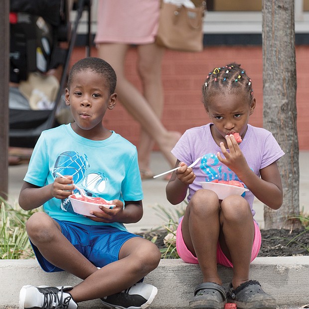 Fun, sun and watermelon //
Kristopher Adams, 6, and his sister, Kristianna, 5, cool off with some juicy watermelon last Sunday at the 34th Annual Carytown Watermelon Festival in Richmond. The free event attracts an estimated 118,000 people each year. In addition to collectively devouring a few thousand watermelons, the crowd enjoyed entertainment from 50 bands and other performers on five stages and browsed the wares of more than 100 street vendors and retail store merchants.