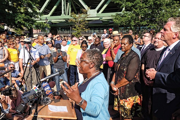 At right, Dr. Cheryl Ivy Green, president of the Baptist Ministers’ Conference of Richmond and Vicinity, leads people in prayer at the gathering where clergy members joined politicians, including Gov. Terry McAuliffe, far right, and Delegate Delores L. McQuinn of Richmond, second from right, and Congressman A. Donald McEachin.