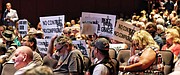 audience members who want the Confederate statues to remain untouched on Monument Avenue hold up signs against any context being added.
