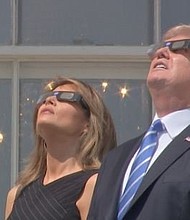 
President Donald Trump and first lady Melania Trump wear glasses to watch the solar eclipse