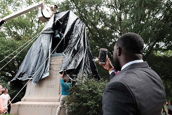 Workers in Charlottesville draped giant black tarps over two statues of Confederate generals on Wednesday to symbolize the city’s mourning ...