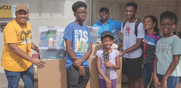 A new wave of freshmen has arrived on Richmond’s college campuses, often accompanied by their families. William P. Agble of Fredericksburg, third from right, moves a cartful of belongings Saturday into Johnson Hall at Virginia Commonwealth University, with help from his family and a student volunteer, left.  Surrounding him, from left, are brother Josh, sister Jemima holding his guitar, father William K. Agble, mother Susie Agble and sister Kaitlyn. William and other students started classes at VCU this week.