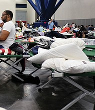 People displaced by the hurricane take shelter in the Houston Convention Center as the slow-moving storm inches its way through Southern Texas on Tuesday.