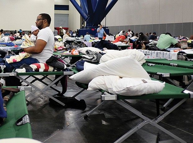 People displaced by the hurricane take shelter in the Houston Convention Center as the slow-moving storm inches its way through Southern Texas on Tuesday.