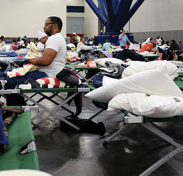 People displaced by the hurricane take shelter in the Houston Convention Center as the slow-moving storm inches its way through Southern Texas on Tuesday.