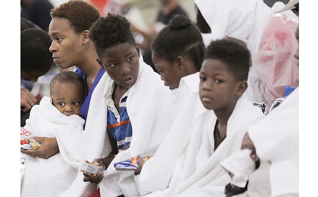 Terranysha Ferguson holds her son, Christian Phillips, as she sits Sunday with the rest of her family at the Houston Convention Center.