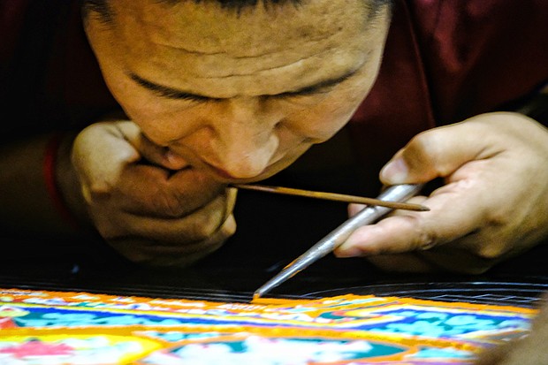 The Tibetan Buddhist tradition begins with chanting and laying out the mandala, then placing the sand, which is painted. The monks held public meditation sessions each evening as the mandala was created. During the Aug. 20 closing ceremony, the mandala was dismantled to symbolize the belief in the transitory nature of material life. Small packets of sand were given to members of the audience. 