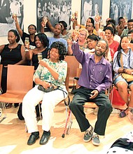 Black woman rising // An audience of about 125 people toast author Arvat McClaine during a book signing and talk last Saturday at the Black History Museum and Cultural Center of Virginia in Jackson Ward. Dr. McClaine’s recently published book, “When Black Women Speak the Universe Listens: A Glimpse Into Our Personal Passage and Rightful Place in the Universe,” focuses on African-American female empowerment. 
