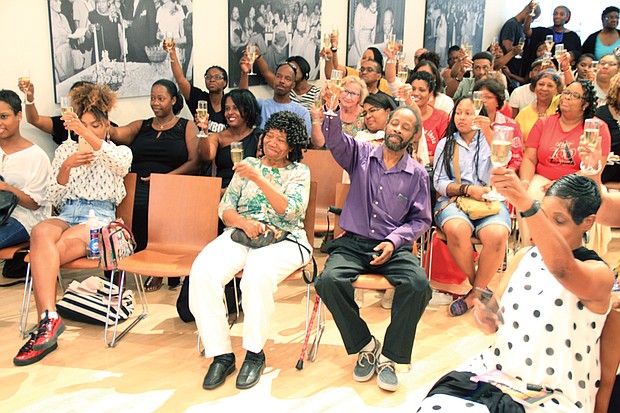 Black woman rising // An audience of about 125 people toast author Arvat McClaine during a book signing and talk last Saturday at the Black History Museum and Cultural Center of Virginia in Jackson Ward. Dr. McClaine’s recently published book, “When Black Women Speak the Universe Listens: A Glimpse Into Our Personal Passage and Rightful Place in the Universe,” focuses on African-American female empowerment. 
