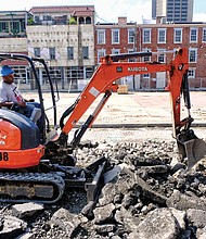 
A worker digs up cobblestones that covered a now closed stretch of 17th Street in Shockoe Bottom. The work is part of the estimated $4.3 million facelift for the Farmers’ Market area, which dates to the 1780s and is among the oldest such marketplaces in the country. The old pavilions, concrete and stones are being removed between Main and Franklin streets to create a European-style plaza with market stalls on the side and an open space for local and regional events. The outdoor setting that is to be finished next year is designed to complement the revamped Main Street Station with its grand indoor event space. Despite the work, businesses located along the street are still open and accessible by the sidewalk.