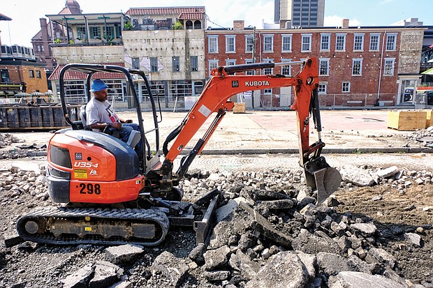 
A worker digs up cobblestones that covered a now closed stretch of 17th Street in Shockoe Bottom. The work is part of the estimated $4.3 million facelift for the Farmers’ Market area, which dates to the 1780s and is among the oldest such marketplaces in the country. The old pavilions, concrete and stones are being removed between Main and Franklin streets to create a European-style plaza with market stalls on the side and an open space for local and regional events. The outdoor setting that is to be finished next year is designed to complement the revamped Main Street Station with its grand indoor event space. Despite the work, businesses located along the street are still open and accessible by the sidewalk.