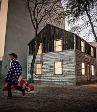 Ryan Mendoza, an American artist, in front of the exhibit he made in Berlin of the Rosa Parks house. (photo: Gordon Welters/NY TIMES)