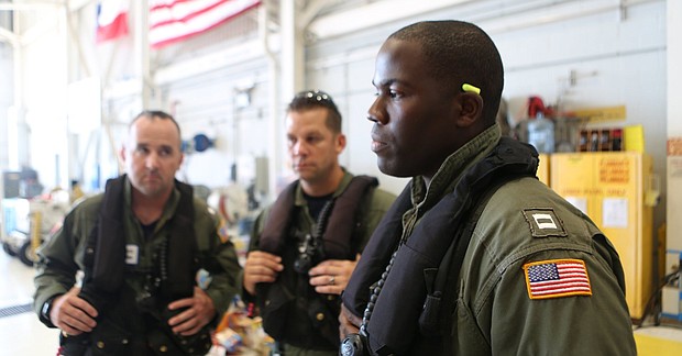 Coast Guard pilot Jason Brownlee, at right, is seen with commander John Egan, left, and flight mechanic Eric Cybulski, center. (MELISSA JELTSEN/HUFFPOST)