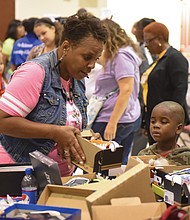 Sharon Toulson of Sharon Baptist Church helps 4-year-old Joshua Ellis choose the perfect pair of shoes.