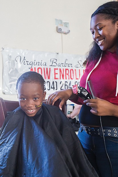 Old school party for new school year //  Antonio Daniels, 7, gets his hair cut by Zeymoria Light,
