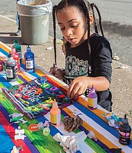 Jaliah Jackson, 4, designs her own binder pouch, at the Back-to-School Block Party held Sunday at the Richmond Association of Masonic Lodges on North 25th Street in preparation for the first day of school. 
