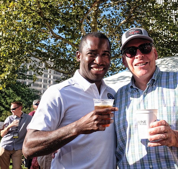 Richmond Mayor Levar M. Stoney, left, and Gov. Terry McAuliffe enjoys a drink in the sunshine during the daylong event featuring six bands.