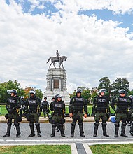 The CSA II: New Confederate States of America rally at the Robert E. Lee statue on Monument Avenue pitted pro-Confederate statue supporters against counterprotesters who want them removed. With a strong police presence and a maze of barricades, the Sept. 16 rally was largely peaceful and without major incidents. // Clement Britt
Police dressed in riot gear circle the west side of the Lee monument. Despite the small number of pro-Confederate demonstrators, there was an overwhelming police presence.