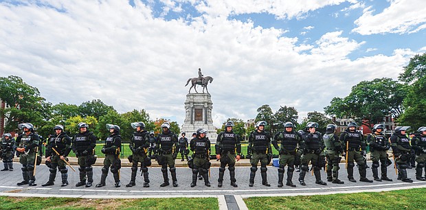 The CSA II: New Confederate States of America rally at the Robert E. Lee statue on Monument Avenue pitted pro-Confederate statue supporters against counterprotesters who want them removed. With a strong police presence and a maze of barricades, the Sept. 16 rally was largely peaceful and without major incidents. // Clement Britt
Police dressed in riot gear circle the west side of the Lee monument. Despite the small number of pro-Confederate demonstrators, there was an overwhelming police presence.