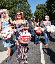 Richmonders Lauren Smith, left, and Katy Johnson hand out white paper roses, a symbol of the resistance in Nazi Germany. They said they learned from a statement by Coretta Scott King that people should wear their Sunday best when they go out to demonstrate.