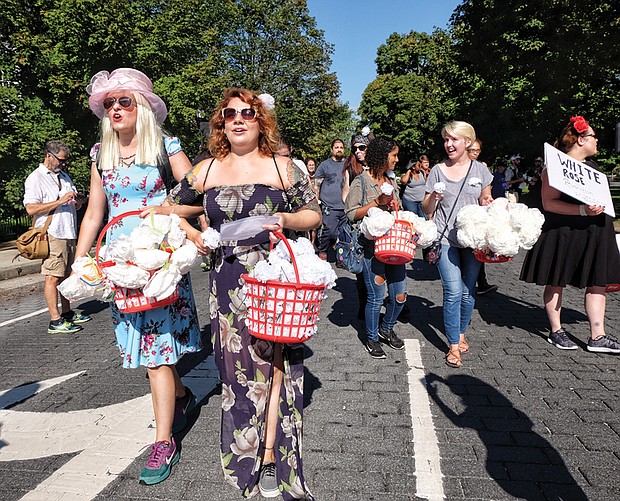 Richmonders Lauren Smith, left, and Katy Johnson hand out white paper roses, a symbol of the resistance in Nazi Germany. They said they learned from a statement by Coretta Scott King that people should wear their Sunday best when they go out to demonstrate.