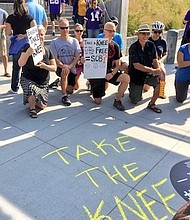 Protesters stand outside US Bank Stadium in Minneapolis to take a knee in solidarity with the team.