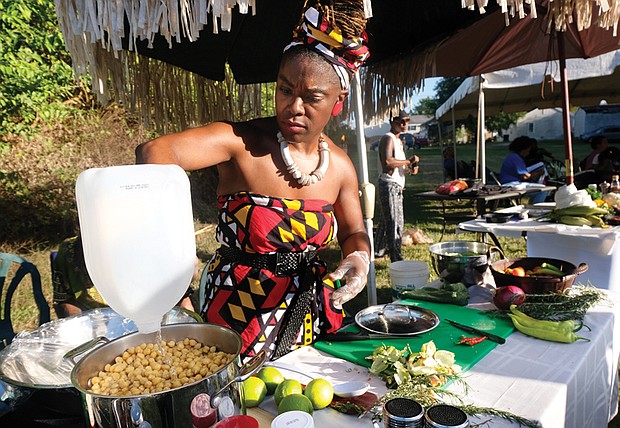 All natural //
Shayola the Artisan prepares a chickpea salad at Happily Natural Day last Saturday at the 5th District Mini Farm on Bainbridge Street in South Side. The festival celebrating African-American culture and hair included presentations on growing food in the community garden. All the vegetables used in the chickpea salad were grown onsite. 