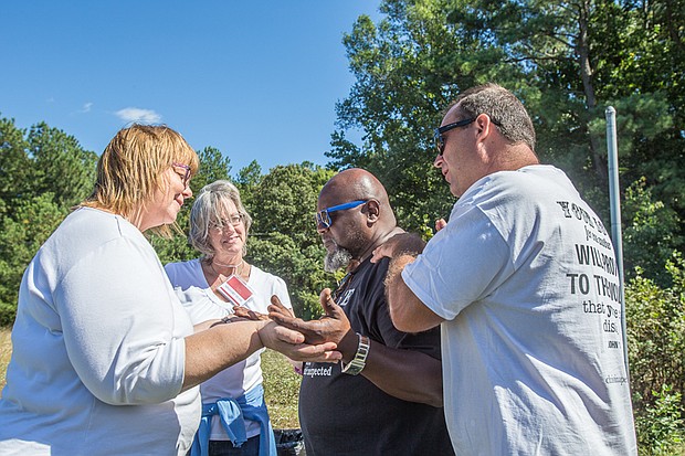 United in prayer //
A coalition of groups welcomed the homeless and others last Saturday to a communitywide faith event, Cookouts for Christ, on Willis Road in South Side. The free event, which featured food and music, also offered testimony by ministry leaders of how Christ turned their lives around from drugs, hopelessness and despair. Joining in prayer at the cookout are, from left, Beth Hextall; Sondra Stephens; Marvin Williams, associate pastor with Grace Alive Ministries; and Jamie Lombardo. The event was sponsored by Christina Perera Ministries in partnership with Harvest Renewal, Dwelling Place and A Place of Miracles Café.
