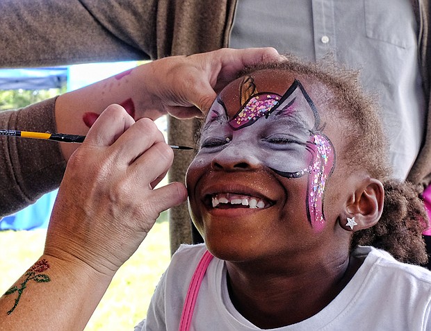 Happy face //
Six-year-old Nia McKoy grins with pleasure as Ivy MacCurtin transforms her face Saturday at the 2017 Richmond Peace Festival at St. Joseph’s Villa in Henrico County. Please see B3 for additional photo coverage. 