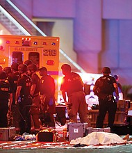 A body is covered with a sheet at an area set up by first responders in the intersection of Tropicana Avenue and Las Vegas Boulevard after Sunday’s mass shooting across from the Mandalay Bay Resort and Casino in Las Vegas. 