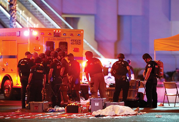 A body is covered with a sheet at an area set up by first responders in the intersection of Tropicana Avenue and Las Vegas Boulevard after Sunday’s mass shooting across from the Mandalay Bay Resort and Casino in Las Vegas. 