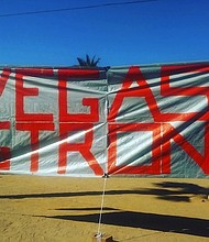 A banner with the words "Vegas Strong" is hung up near the iconic Las Vegas sign. The banner is a tribute to the victims of the Vegas concert shooting on October 1st, 2017 as well as the LVMPD.