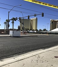 The Mandalay Bay hotel has broken windows the day after a mass shooting from the 32nd floor of the hotel. Crime scene tape and dried blood platters on the sidewalk.