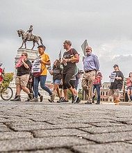 Rallying for rights //
Coalition for Accountability members gather last Tuesday near the Robert E. Lee statue on Monument Avenue and walk to Shockoe Bottom to demand the removal of Confederate statues, better schools, expanded public transportation and immigration and LGBTQ rights.