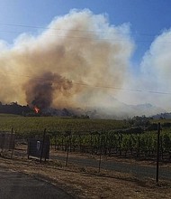 	Joseph  Pader watches his neighbor's home burn after fires in Napa, California.