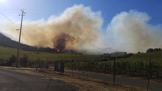 Joseph Pader watches his neighbor's home burn after fires in Napa, California.