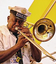 Folk Festival turns up lively music, crowd //  Dwayne Paulin, a trombonist for the Paulin Bass Band, plays traditional New Orleans jazz.