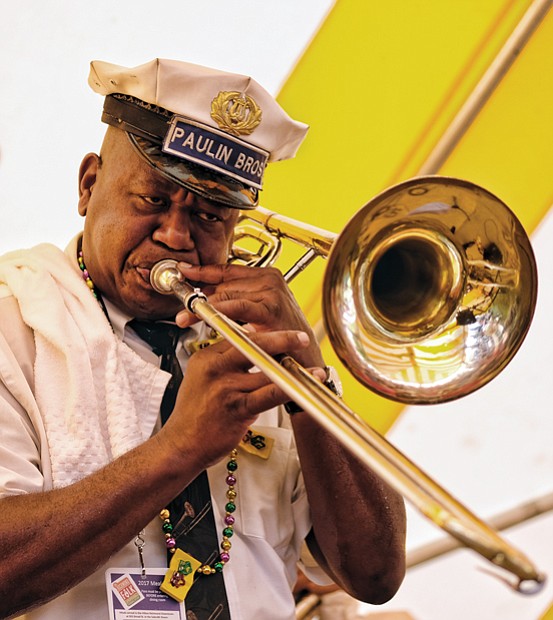 Folk Festival turns up lively music, crowd //  Dwayne Paulin, a trombonist for the Paulin Bass Band, plays traditional New Orleans jazz.