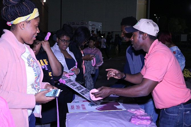 Ernst Lamothe Jr. Passes out poster boards and headbands at the Pink Out Events at SD 215 TF North High School