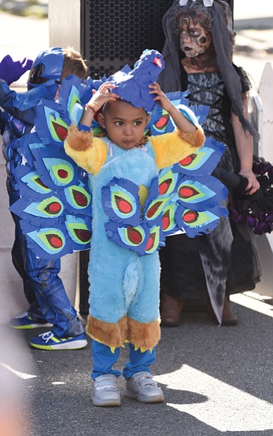 Getting in character // Aaray Kota, 3, adjusts the mask of his peacock costume, left, as he and other characters prepare for the Kids Costume Contest at the Scott’s Addition Pumpkin Festival last Saturday on the Boulevard. 
