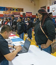 Bridging the digital divide //
Ta’Niyah Brown, right, is one of 1,050 Richmond high school freshmen receiving a new, internet-connected computer tablet, courtesy of Sprint. Watching the distribution at George Wythe High School, is interim schools Superintendent Thomas E. “Tommy” Kranz, far right. Officials from the wireless communication company and its foundation gave students the free equipment and wireless service at the Oct. 19 event. Through the next four years, a total of 5,250 city students who lack computers and internet service at home will receive electronic tablets to help them do their homework. The distribution is part of the company’s 1Million Project that seeks to close the digital divide that makes it difficult for students to achieve academic success. 