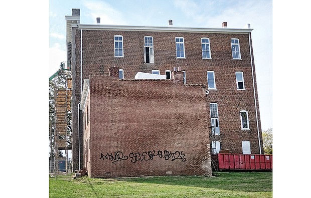 Graffiti mars bricks on the annex to the historic St. Luke Building at 900 St. James St. in Gilpin Court. Now vacant, the annex provided housing for visiting agents of the former Independent Order of St. Luke. The owners lack permits to fence both buildings.   