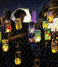 Lanterns decorated by participants hang on a fence before the event’s Lantern Parade. 