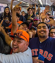 Astros fans celebrate on METRORail as they head to Friday's parade./METRO